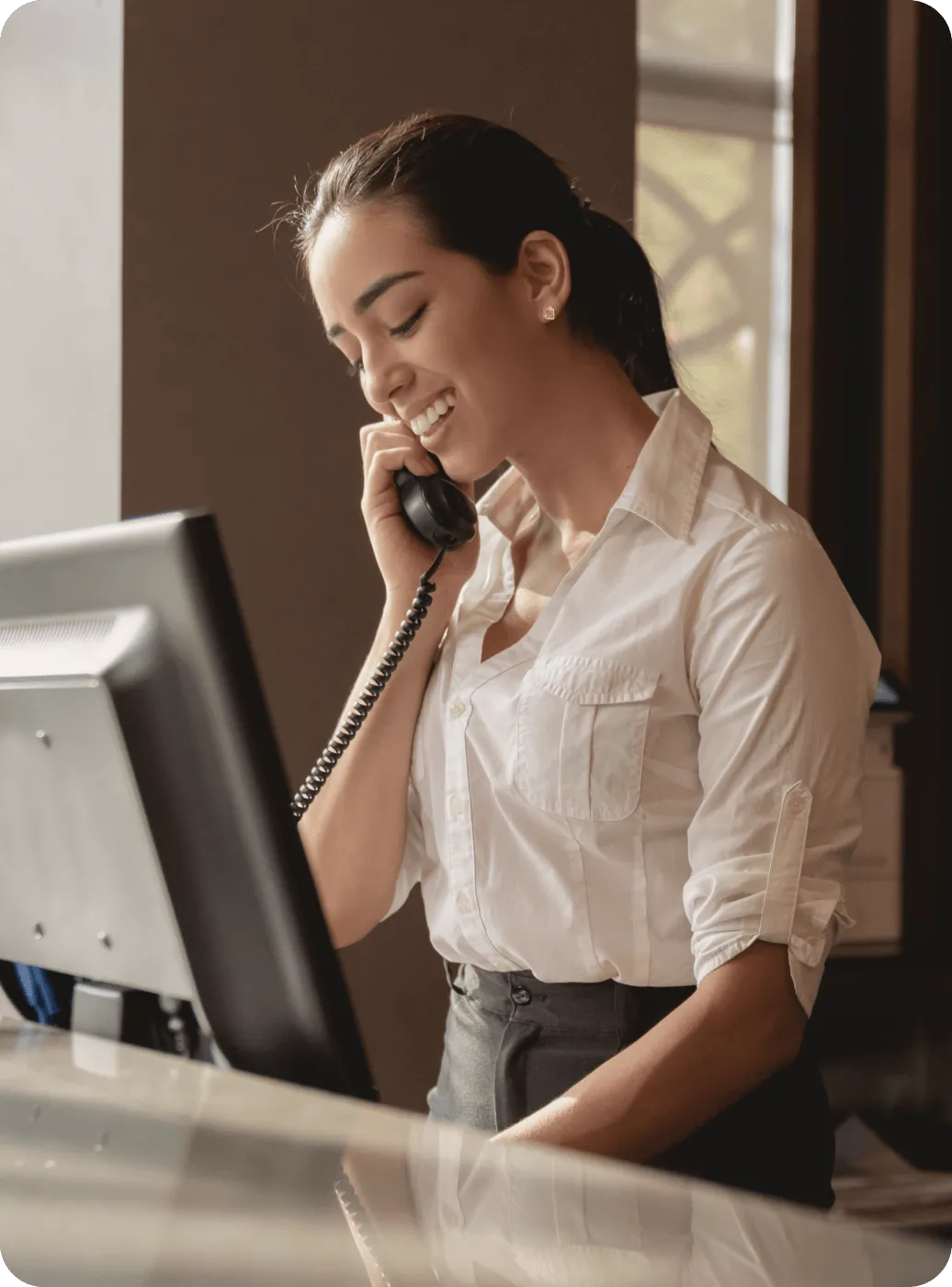 A female receptionists answering a phone call on an IP phone handset