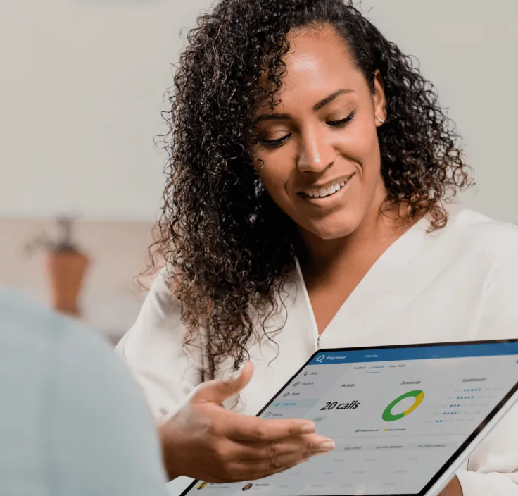 A sales representative showing sales data from her tablet