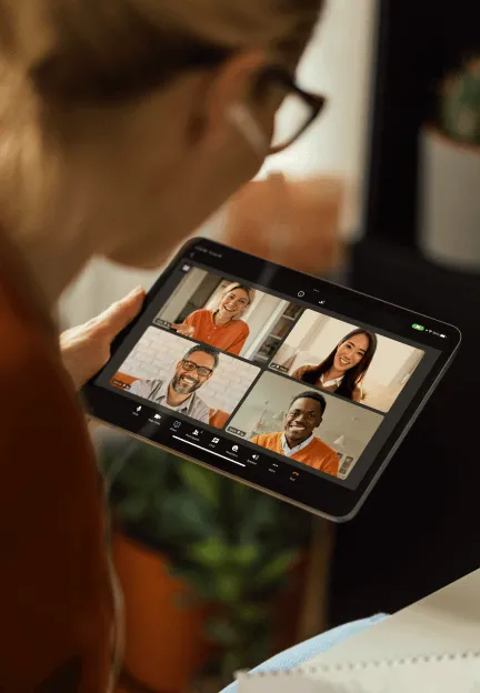 A woman using her tablet for a virtual video meeting with her peers