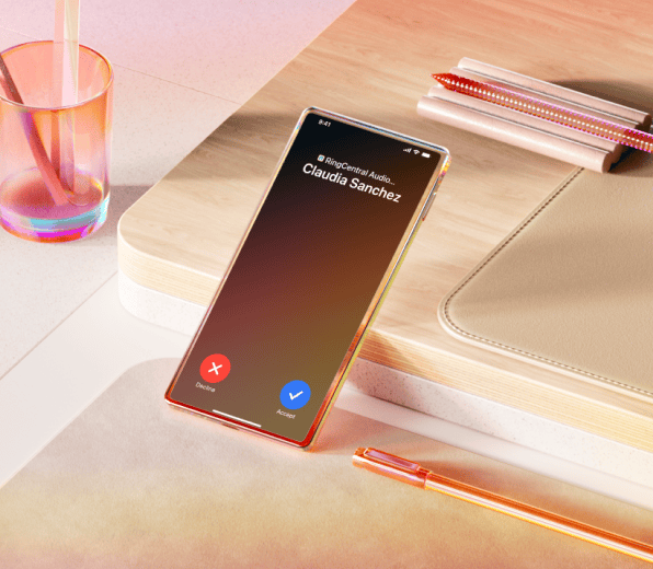 An incoming call notification from Claudia Sanchez on a mobile device in a wooden desk