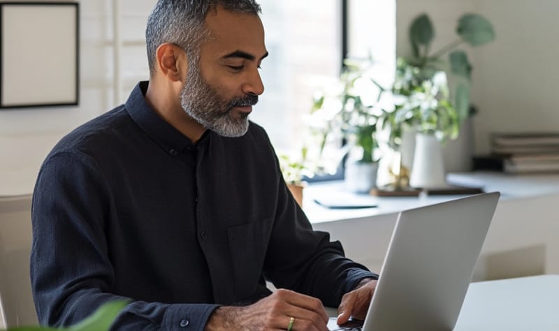 A man on a laptop using RingCentral AI Assistant