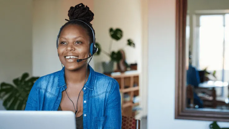 A female agent on a call in front of a laptop