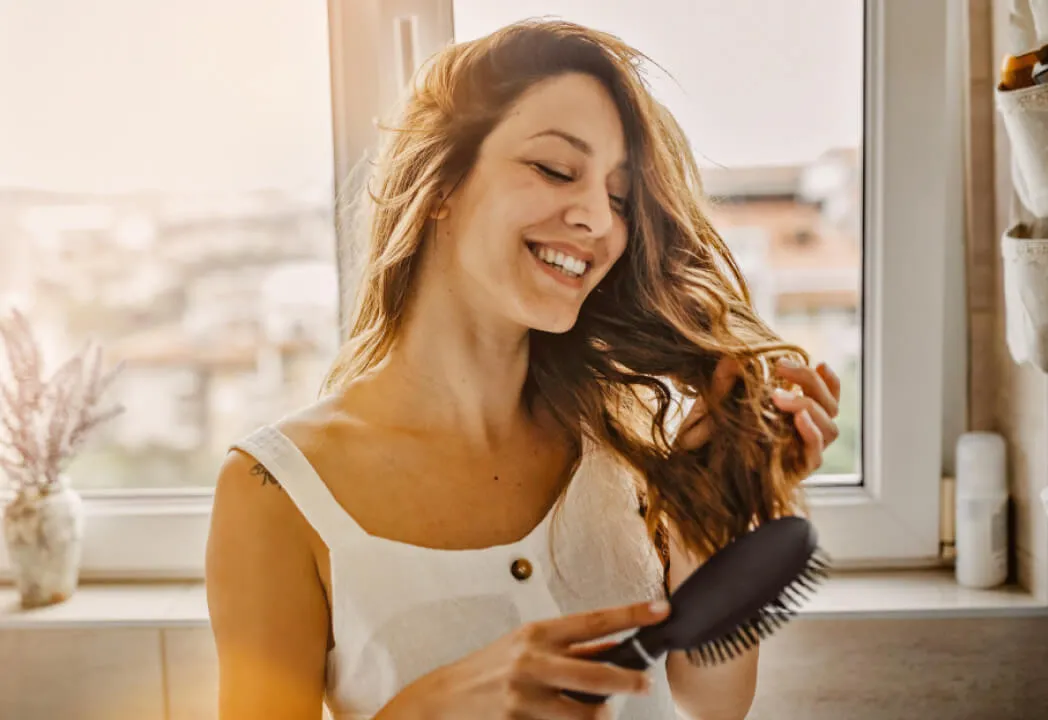 Woman detangling hair with a Conair hair brush